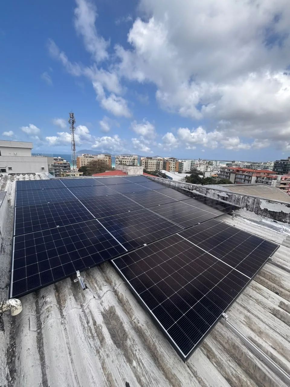 Sistema instalado em telhado com vista para a região costeira.